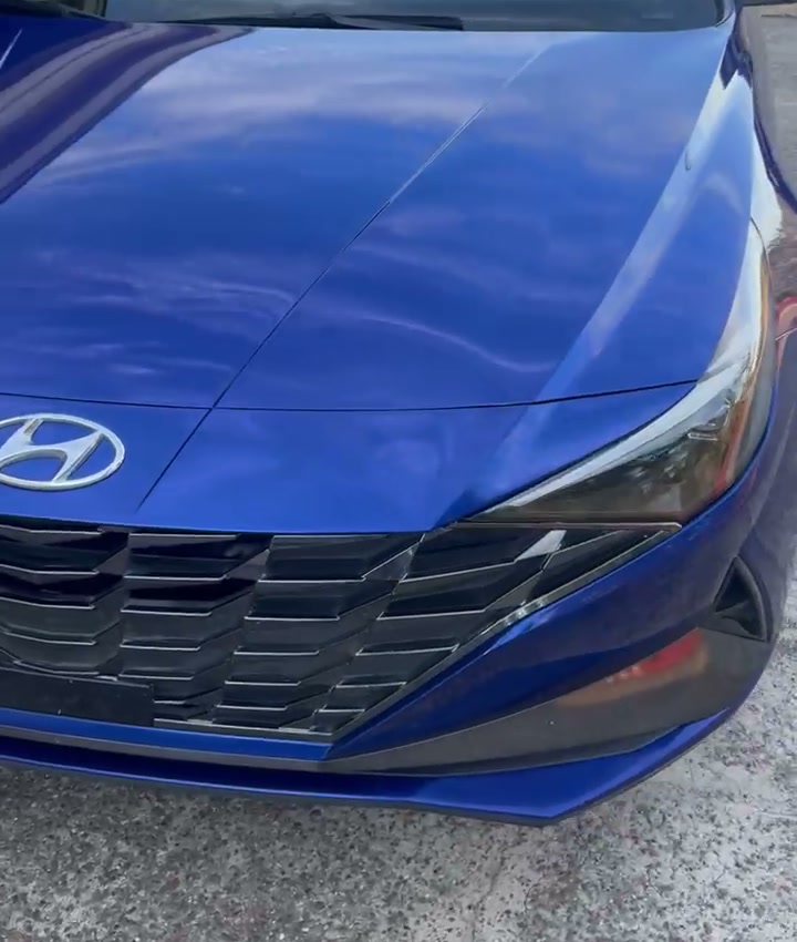 Same blue Hyundai Elantra with its finished front bumper installed after repair