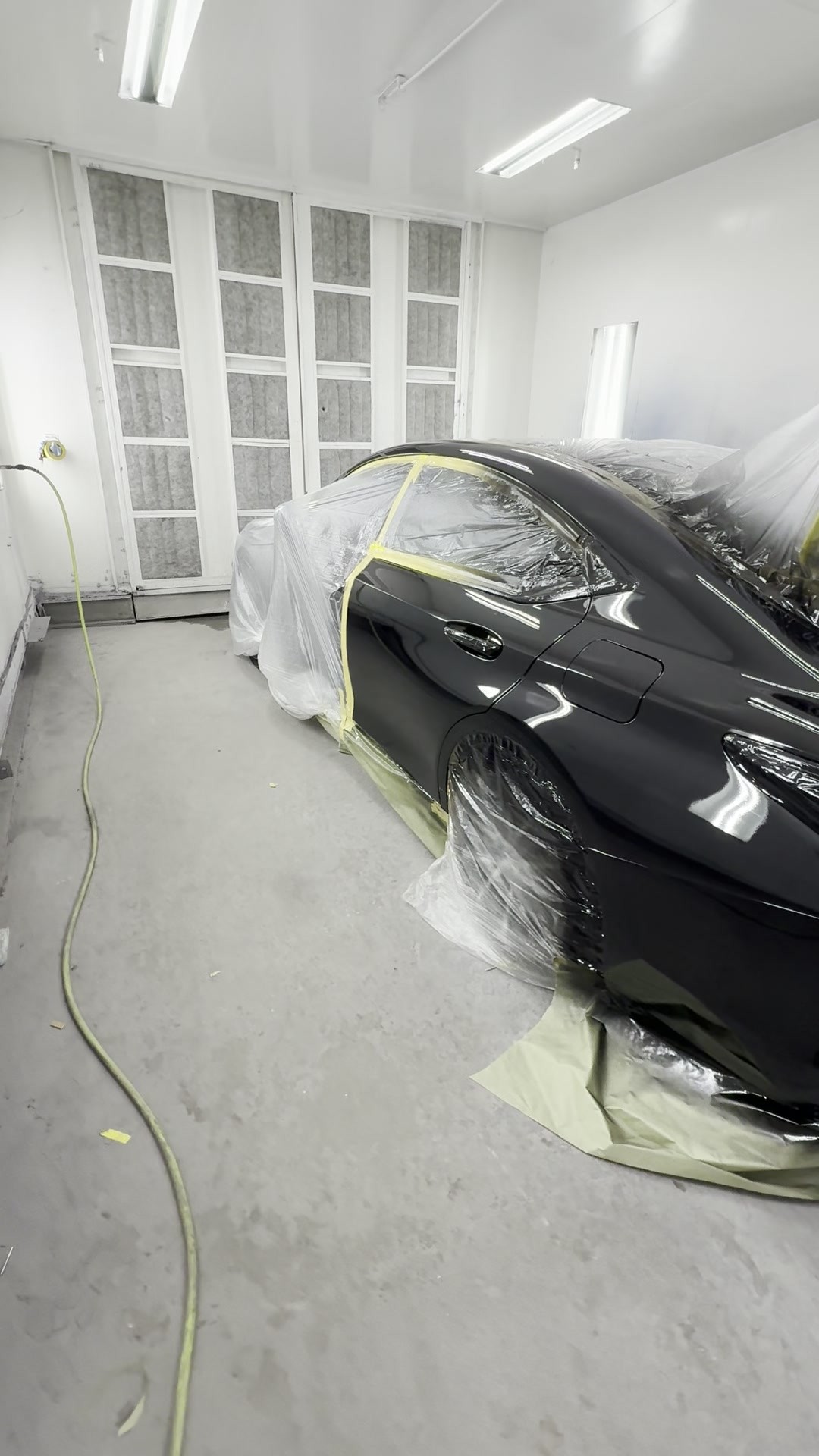 Masked Lexus ES 350 with freshly refinished side panels in the INC Collision paint booth